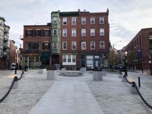Image of paved public square surrounded by brick buildings