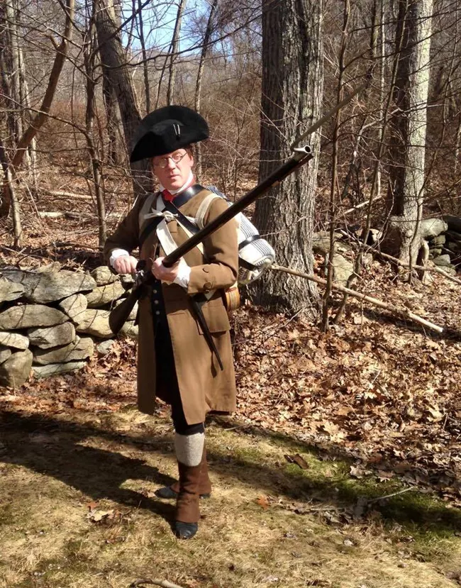 a colonial reenactor dressed as a massacussetts militiaman