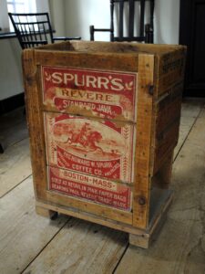 Large wooden crate with red and white text saying Spurr's Coffee and an image of a man on horseback.