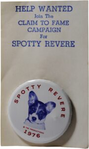 A campaign style button on a cardboard backing.