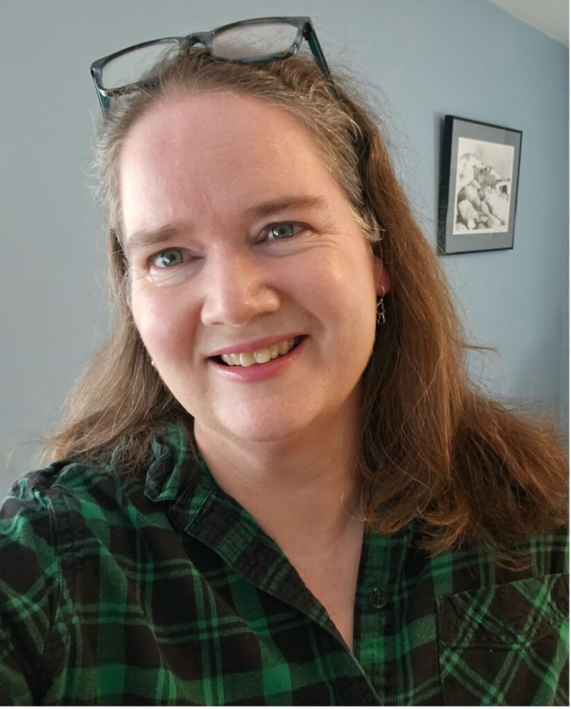 Image of Kerry Dunne, a smiling white woman with glasses perched on her head.
