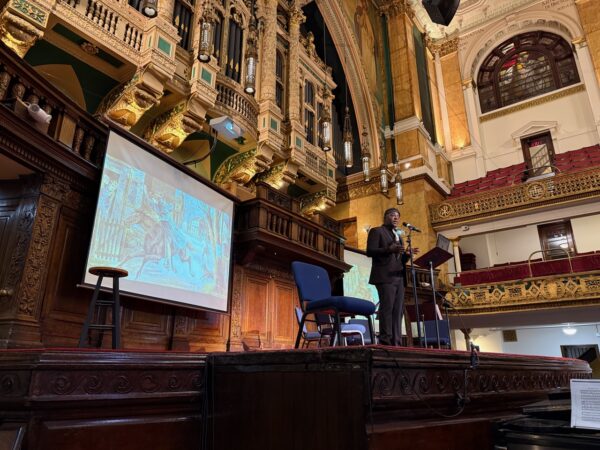 Commonwealth of Massachusetts poet laureate Regie Gibson on stage at Converse Hall, performing Forge, Shape, Shine!
