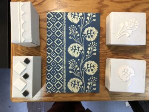 a photograph of a reproduction of the paul revere house's wallpaper, and the blocks used to print it