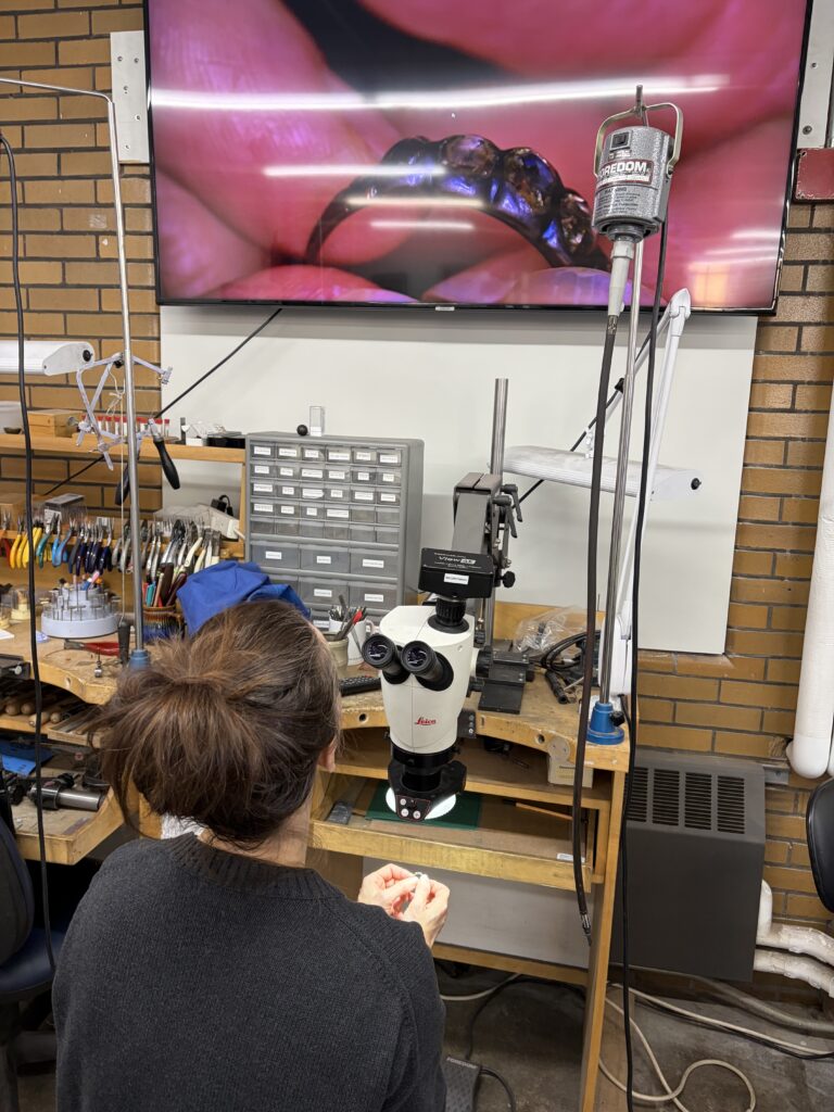 a technician at North Bennet St. School examines the ring with a magnifying camera