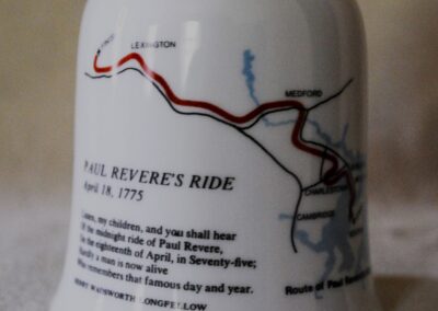 the back of a white ceramic bell, showing a map of the route of Paul Revere's Ride, and the first stanza of Henry Wadsworth Longfellow's "Paul Revere's Ride"