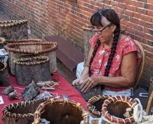 Jennifer Lee demonstrates bark basket weaving in the Revere House courtyard